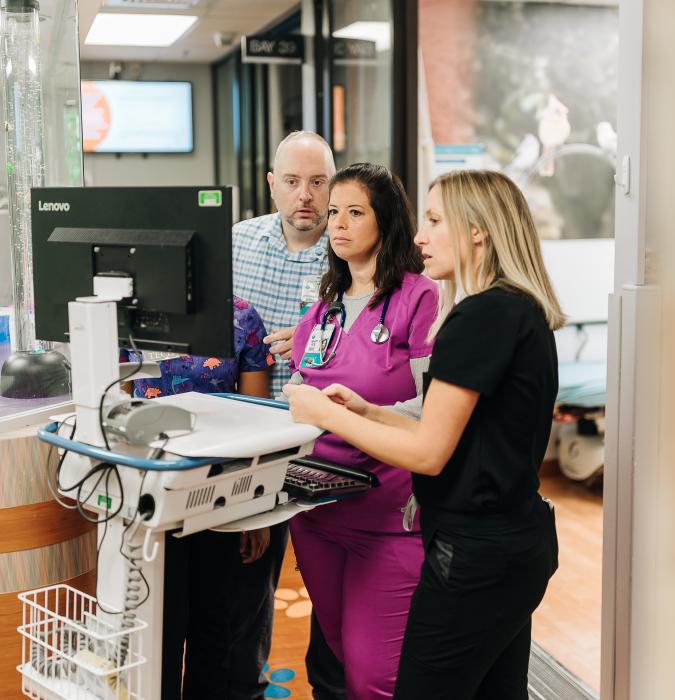 nurses standing around computer